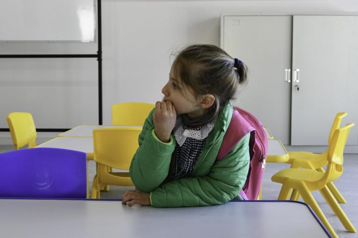 Niña sentada en un mesa en un jardín de infantes de la ANEP