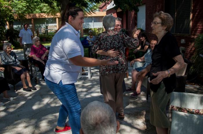 Cuidadora y mujer mayor en actividades en el patio del Centro de Larga Estadía de Colonia Miguelete