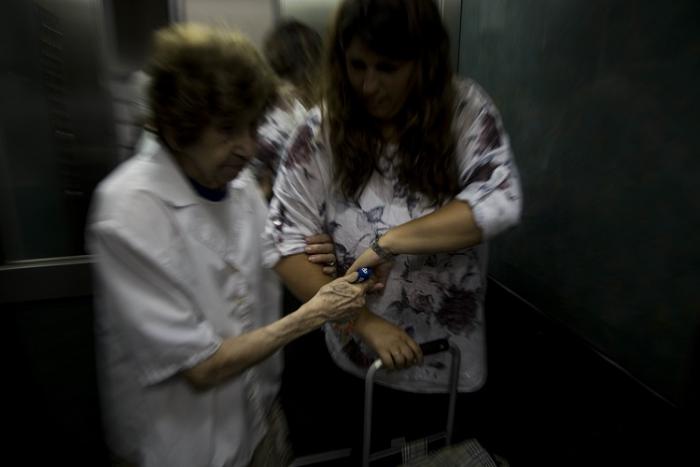 Cuidadora con mujer mayor en el ascensor de su casa