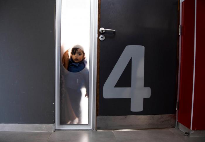 Niño espera dentro de un salón de un centro CAIF