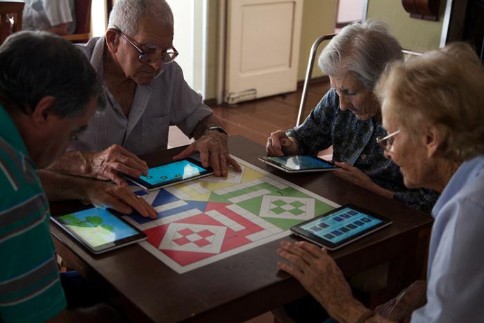 Personas mayores que residen en un hogar de Colonia Miguelete navegan por internet en sus tablets