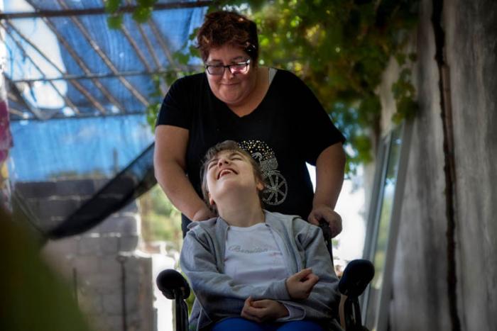 Rosanela, asistente personal, ayuda a sentarse a Nati, una adolescente en situación de dependencia Rosanela, asistente personal, ayuda a sentarse a Nati, una adolescente en situación de dependencia
