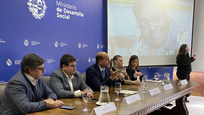 Firma convenio Mides Inacoop Plan Piloto cooperativas asistentes personales Nicolás Scarela, Martín Fernández, Martin Lema, Andrea Brugman y Florencia Krall en la mesa