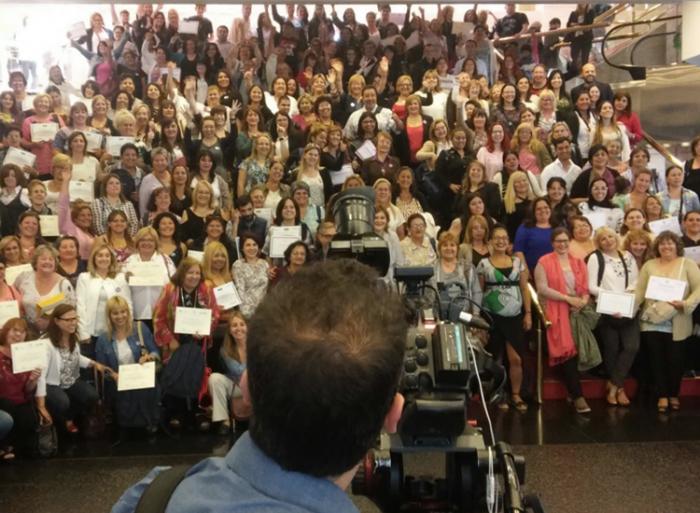 Egresadas muestran sus diplomas en la escalera del Auditorio Adela Reta 