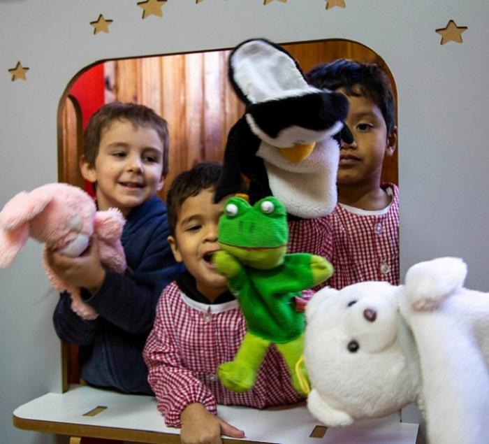 3 niños juegan con títeres en jardín de infantes 3 niños juegan con títeres en jardín de infantes