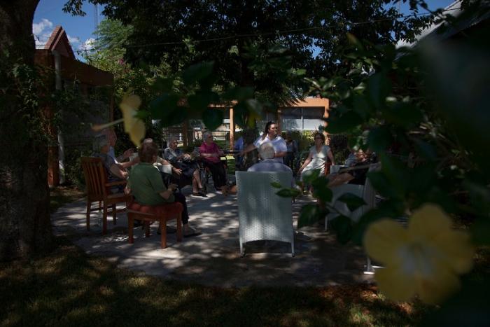 Jubilados sentados en ronda en el patio del centro de larga estadía en Colonia Miguelete