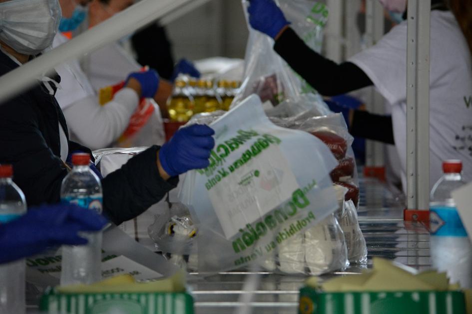 Personas voluntarias cumpliendo todos los protocolos de higiene y seguridad para armar las canastas que serán distribuidas a través de ONFI