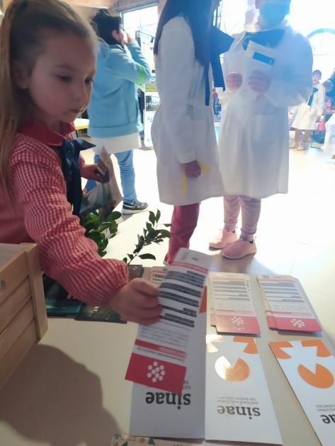 Niños mirando los materiales de sensibilización del Sinae en el Día de la Educación Rural