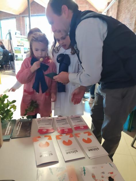 Niños mirando los materiales de sensibilización del Sinae en el Día de la Educación Rural