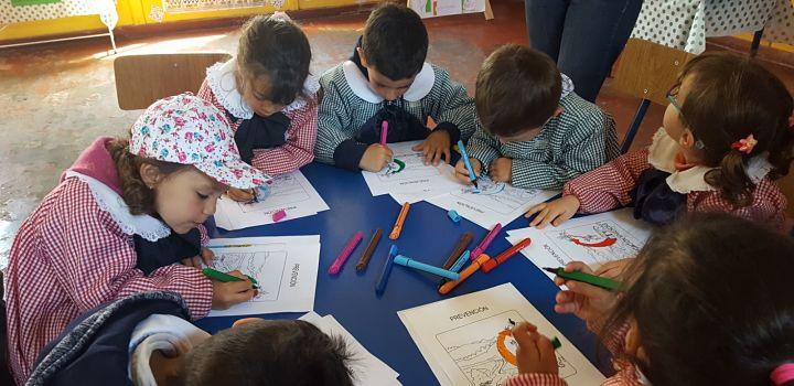 Escolares dibujando sobre gIR en escuela rural