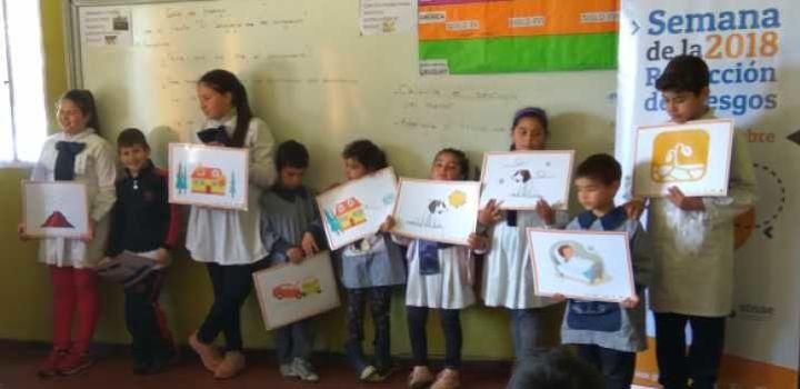 escolares en taller con carteles referidos a gestion de riesgos