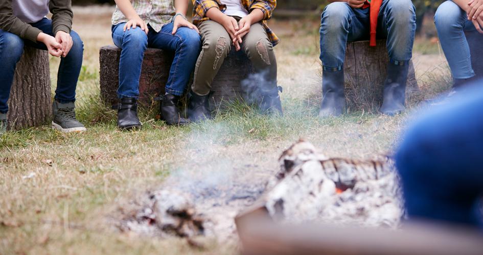 personas sentadas en torno a un fogón seguro