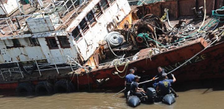 tareas de refacción Barco semi hundido, autoridades caminando por la calle del costado