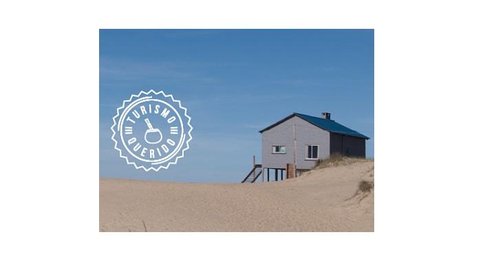 Imagen de una casa en la playa sobre las dunas