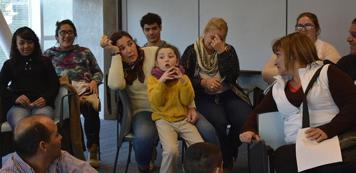 Mujeres y una niña participando de una capacitación. La niña está hablando. 