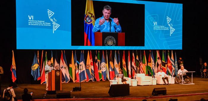 Autoridades sobre el escenario, banderas de fondo