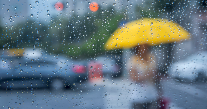 Persona con paraguas fondo de lluvia difuso
