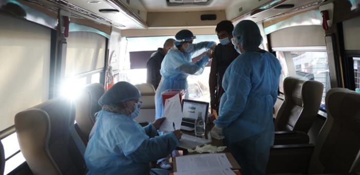 Personal de la salud aplicando vacunas contra COVID-19 en el vacunatorio móvil del Sinae