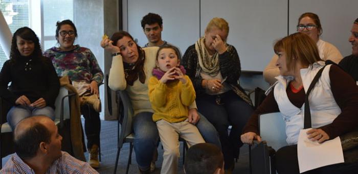 Mujeres y una niña participando de una capacitación. La niña está hablando. 