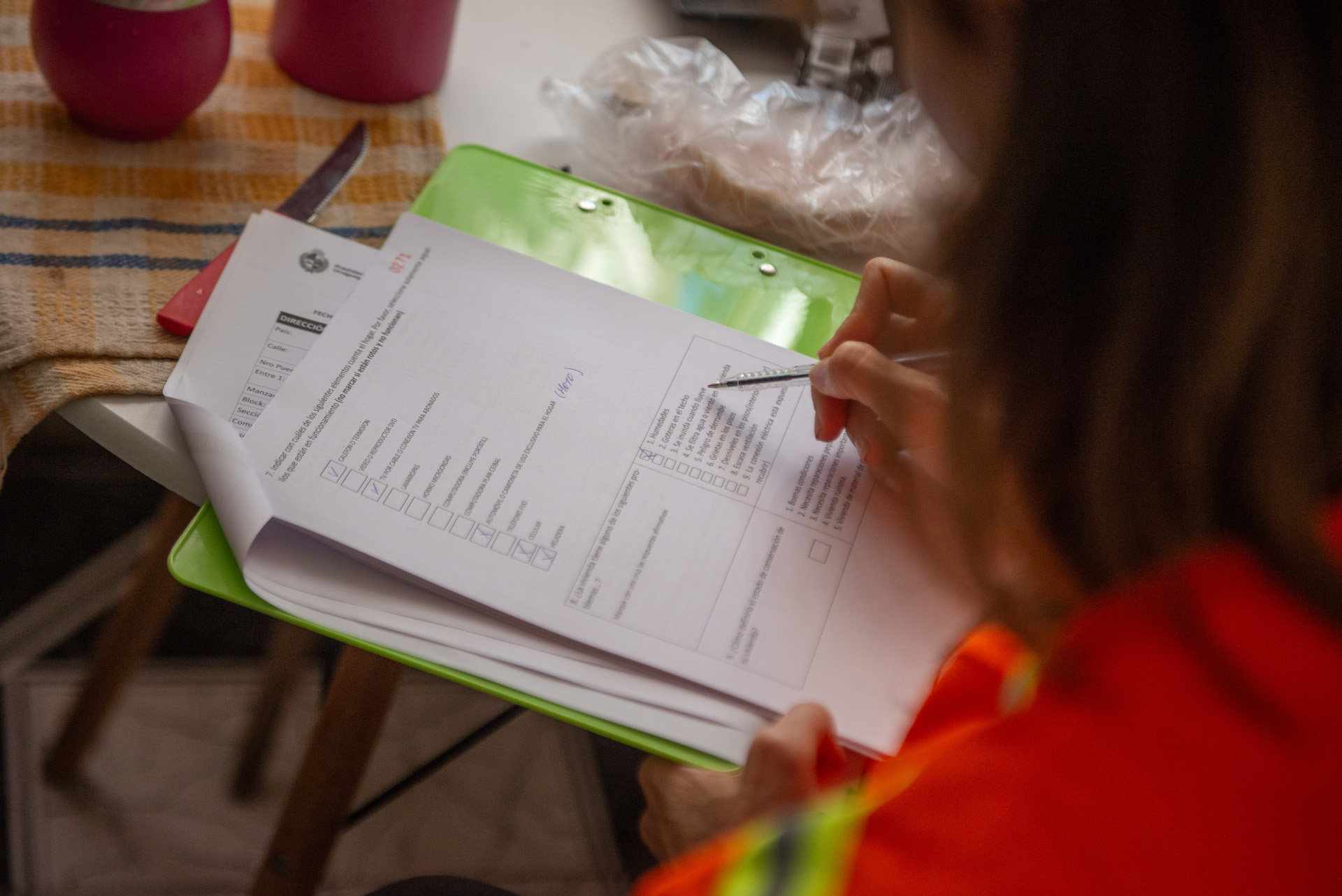 Integrante de Más Barrio completa un formulario durante una encuesta domiciliaria.