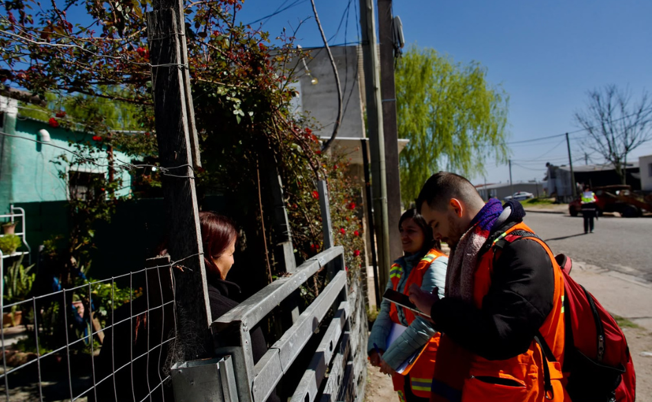 Integrantes de Más Barrio conversan con una vecina durante el relevamiento frente a una vivienda.