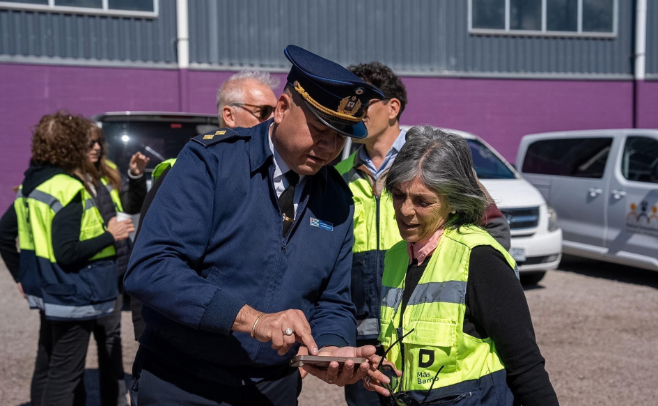 Un policía y la coordinadora de Más Barrio, SIlvana Nieves, miran un celular en el barrio Las Higueras de Durazno