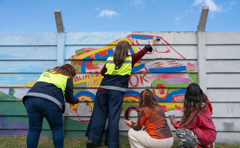 Cuatro mujeres pintan el mural de la plaza de deportes n°10, en Cerro Norte, durante la jornada de integración de Más Barrio celebrando el comienzo de la primavera