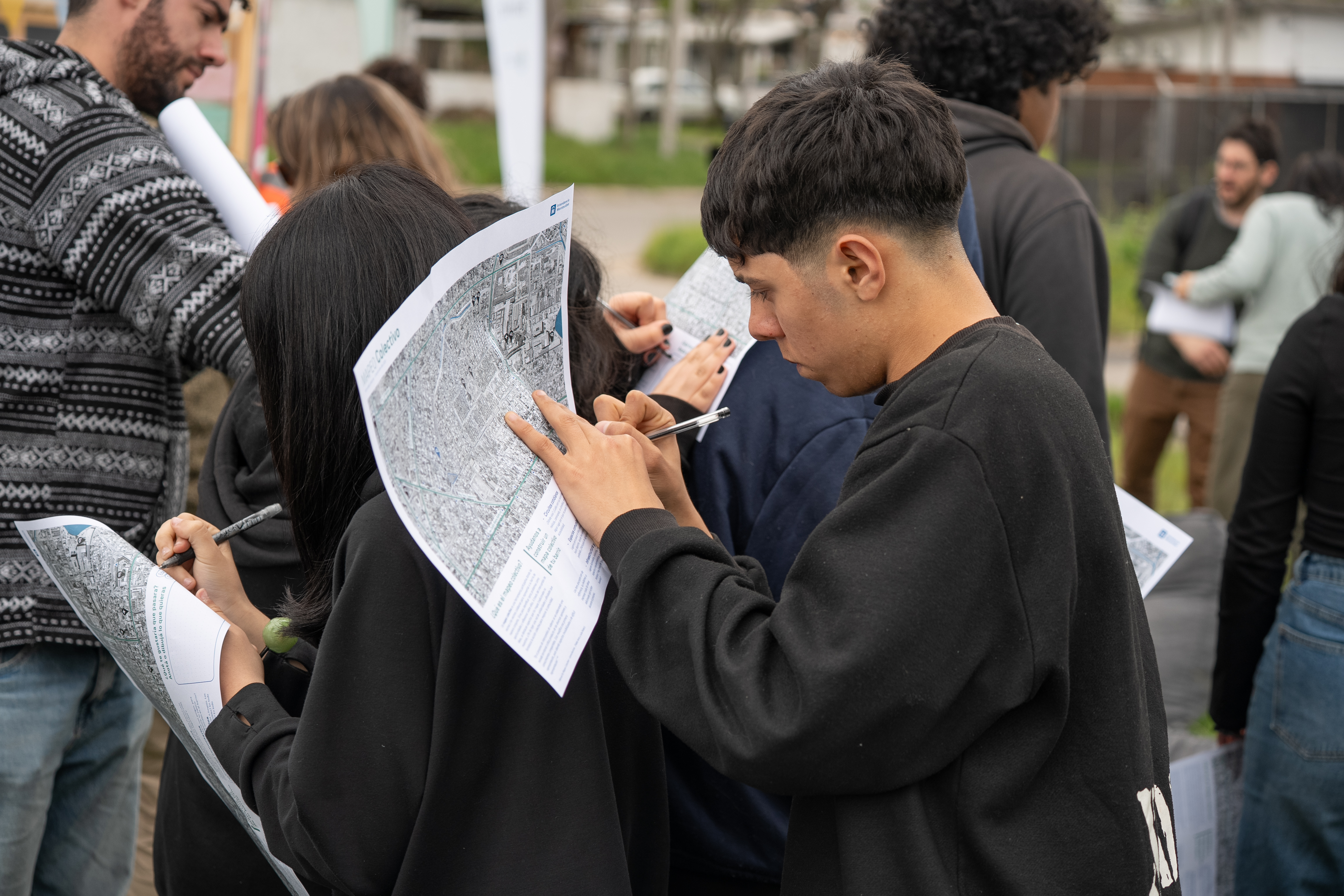 Adolescente integrante de Ni Silencio Ni Tabú escribe sobre un plano de Cerro Norte, durante el taller participativo para diseñar la plaza Conexión 