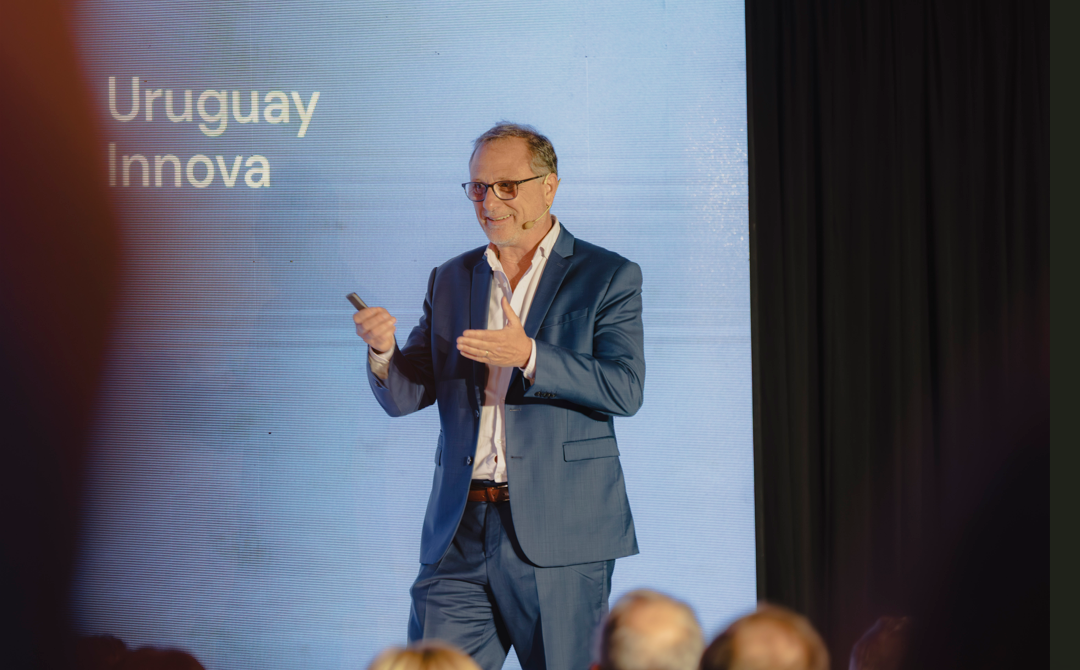 Bruno Gili habla a la audiencia. Detrás el logo de Uruguay Innova