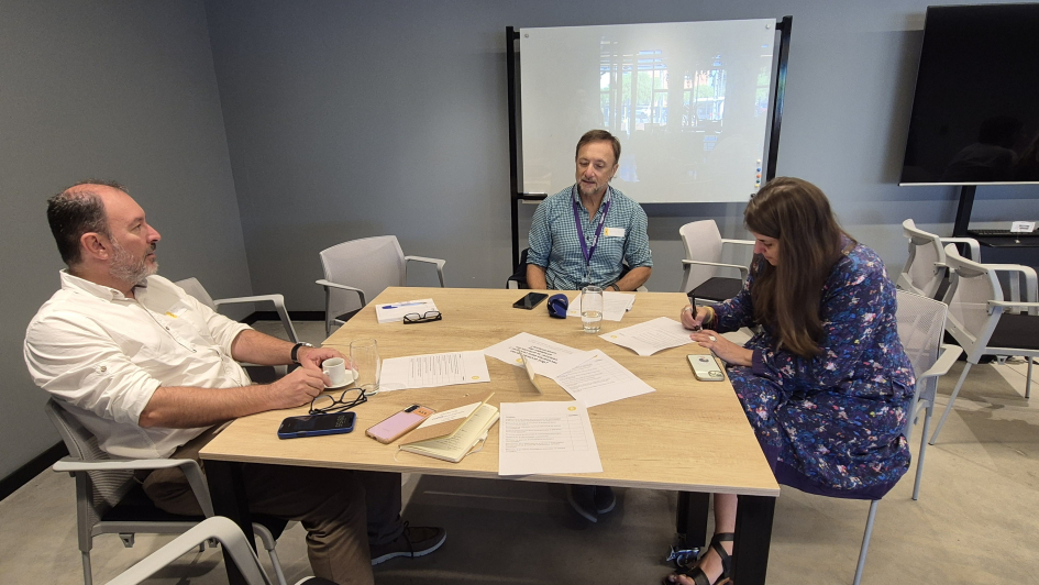 Representantes técnicos sentados alrededor de una mesa discutiendo