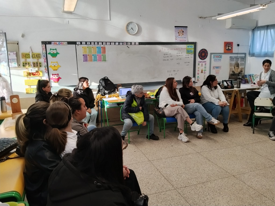 Personas reunidas en salón de escuela.