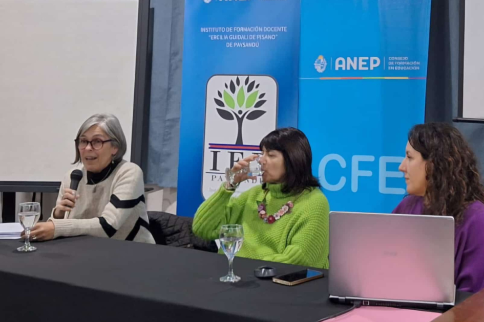Tres personas, una hablando, la otra bebiendo agua y la tercera, mirando para el costado.