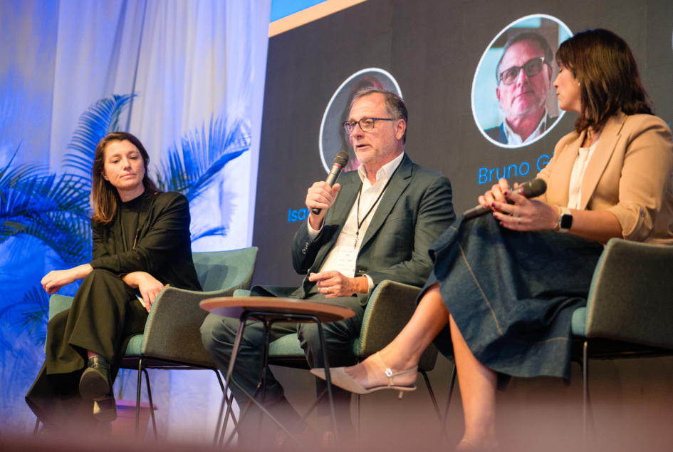 Bruno Gili habla sobre un escenario. Junto a él Mariana Ferreira e Isabela Antonaccio