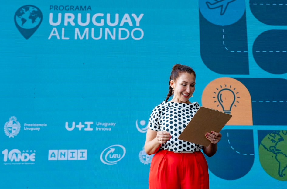 Maestra de ceremonias, con un microfono, se dirige al público