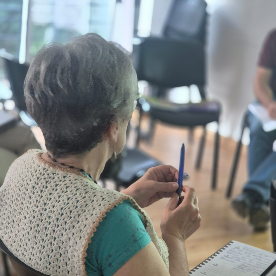 Participante del taller anotando en su cuaderno