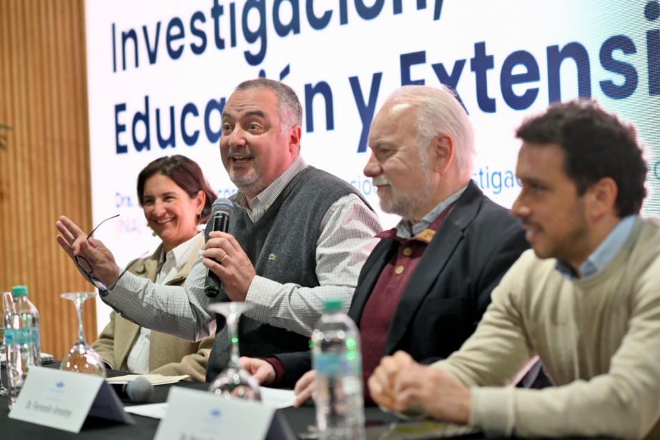Panelistas sentados detrás de una mesa