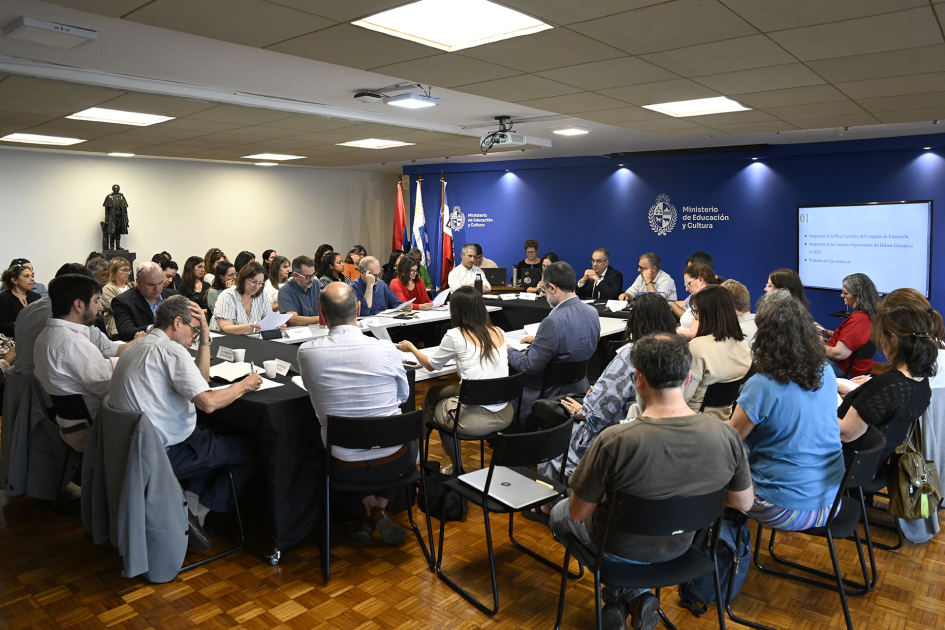 Sala con varias personas sentadas en sillas conformando una ronda.