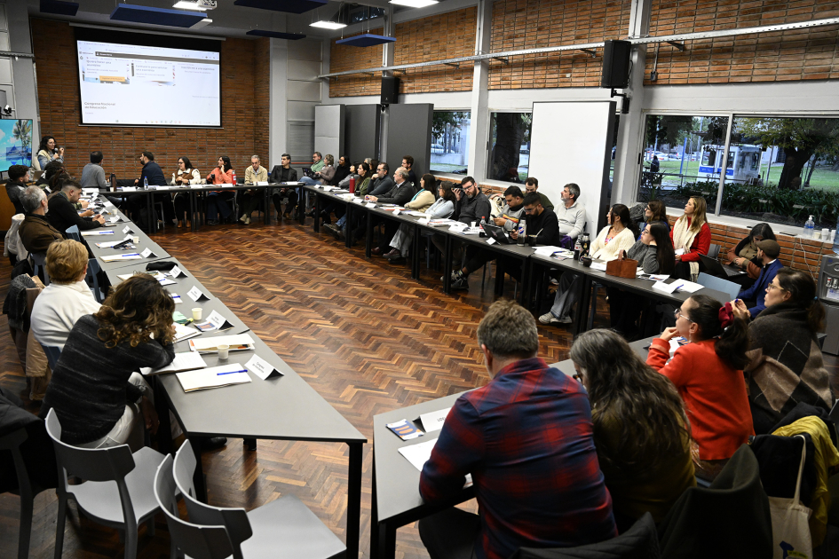 Personas sentadas en formato mesa redonda en sala de la Udelar.