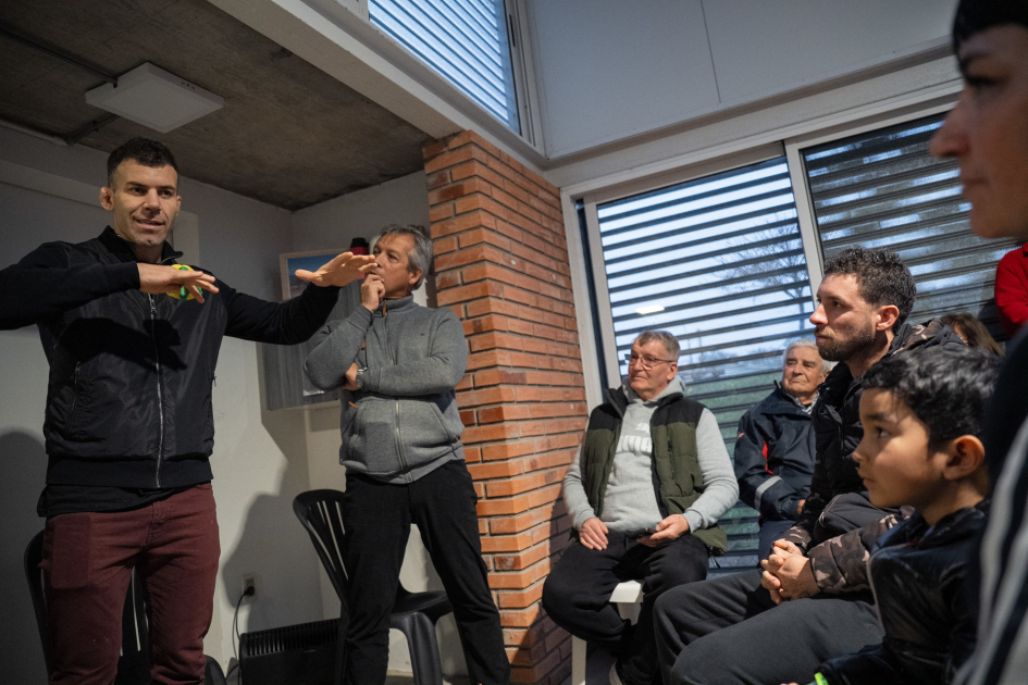 Gastón Reyno habla ante jóvenes y familias durante una charla en la plaza de deportes de Cerro Norte