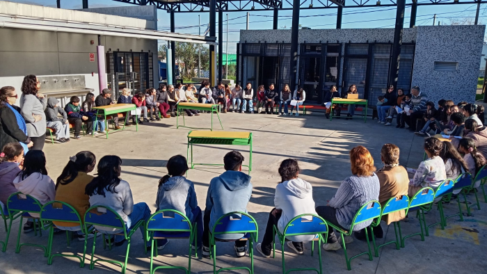 Personas en ronda en patio de una escuela.