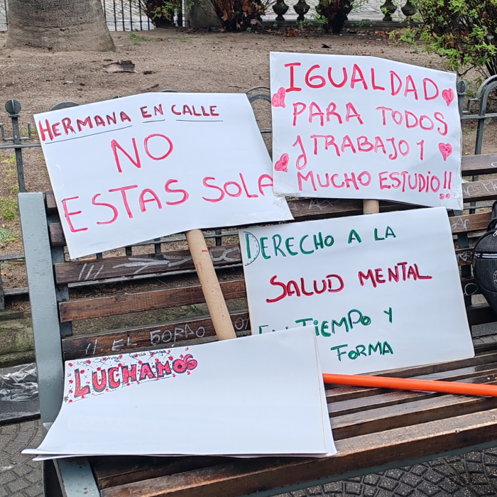 En un banco de plaza se observan varios carteles que reivindican la importancia de la salud mental