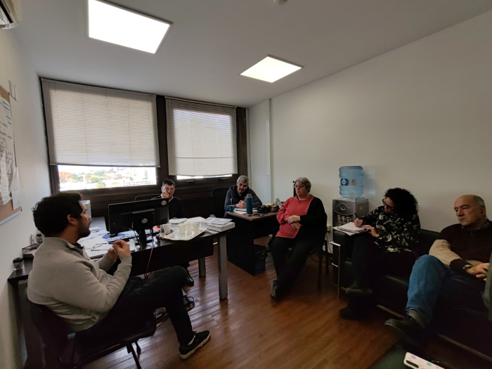 Reunión del titular de la Defensoría y representantes de ASSE en una oficina, dialogando.
