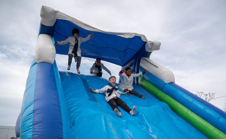Niños de túnica juegan en un inflable durante la celebración del Día de la Niñez en Cerro Norte