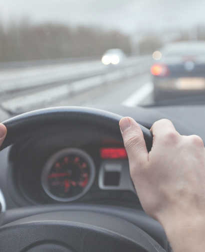 Manos de hombre sobre volante de auto.