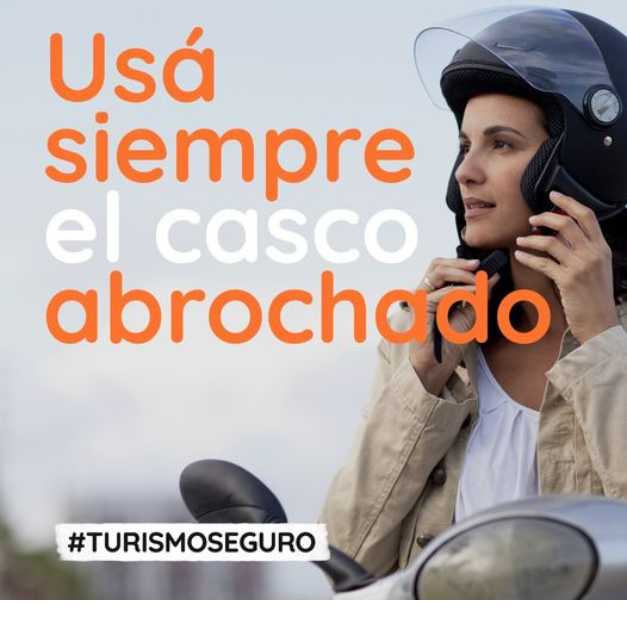 Mujer en moto abrochándose el casco 