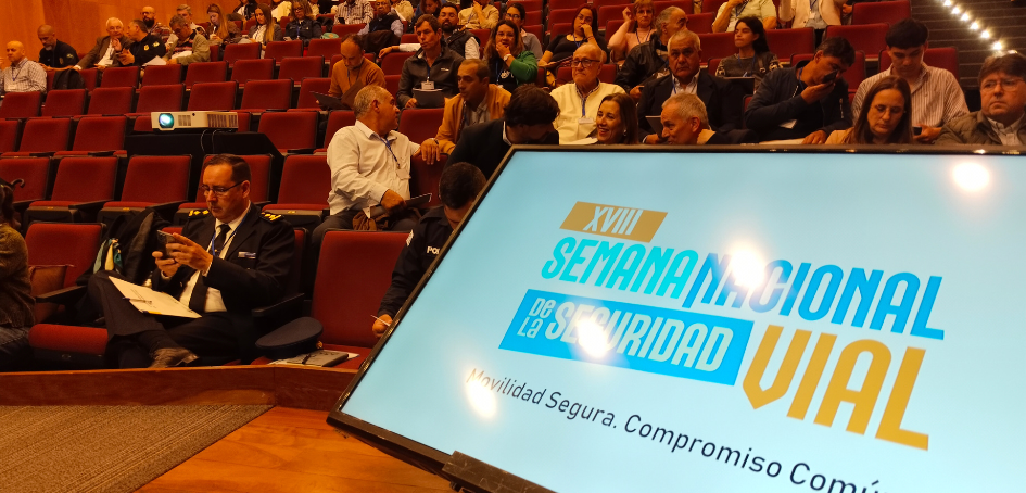 Imagen del auditorio encabezado por la pantalla que anuncia la Semana Imagen del auditorio encabezado por la pantalla que anuncia la Semana