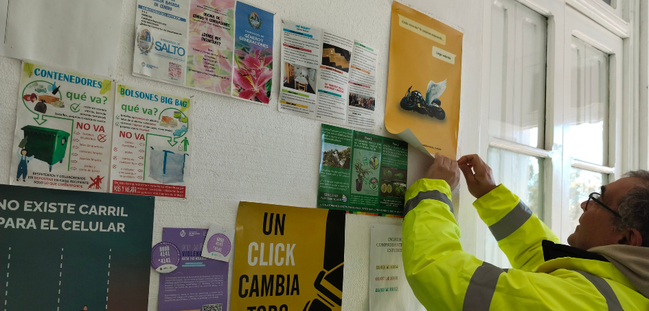 Inspetor de Tránsito pega afiche informativo en cartelera Inspetor de Tránsito pega afiche informativo en cartelera