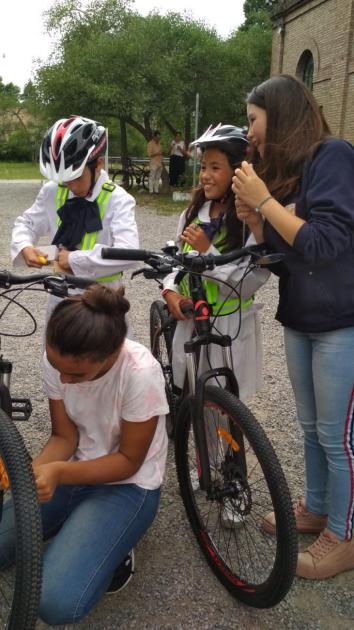 Chiquilines preparando las bicicletas con los elementos de seguridad vial