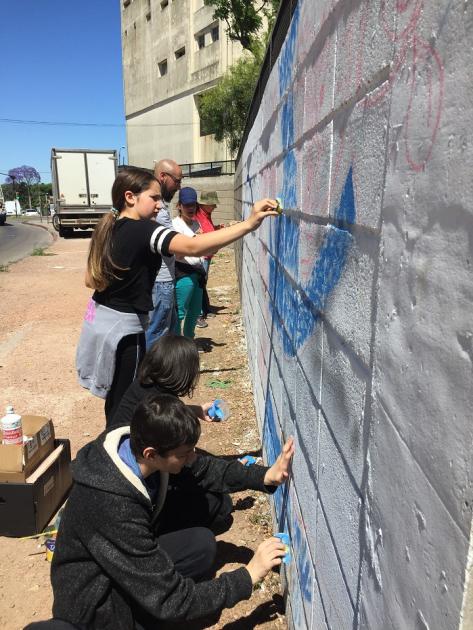 Estudiantes dibujando el mural