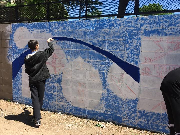 Estudiantes dibujando el mural